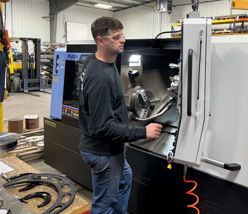 Machinist touching machine tool off on the probe of a Doosan Puma lathe